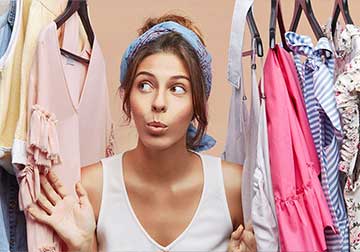 Woman holding hanger with in wardrobe